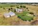 Aerial view of the property with outbuildings, fenced yard, and a decorative round garden at 14475 Lanewood St, Brighton, CO 80603