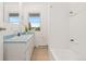 Bright bathroom featuring a single sink vanity, toilet, and shower/tub combination at 14475 Lanewood St, Brighton, CO 80603