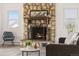 Close-up of the stone fireplace, complete with decorative mantel and metal fire screen at 14475 Lanewood St, Brighton, CO 80603