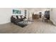 Open-concept living room featuring wood floors and a view of the updated kitchen at 14475 Lanewood St, Brighton, CO 80603