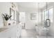 Bright bathroom with double sink vanity, soaking tub, glass enclosed shower, and updated fixtures and lighting at 2571 S Cherokee St, Denver, CO 80223