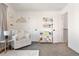 Bright bedroom with a chair, mountain decor, a full bookcase, and plush neutral carpeting at 2571 S Cherokee St, Denver, CO 80223