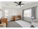 Charming bedroom featuring a window, ceiling fan, wooden crib, and neutral decor at 2571 S Cherokee St, Denver, CO 80223
