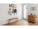 Bright entryway featuring a wooden bench, storage cabinet, and decorative wall art at 2571 S Cherokee St, Denver, CO 80223