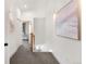 Bright hallway featuring white walls, recessed lighting, and contemporary artwork, leading to the living area at 2571 S Cherokee St, Denver, CO 80223