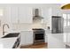 Updated kitchen featuring stainless steel appliances, and modern cabinets with brass hardware at 2571 S Cherokee St, Denver, CO 80223