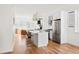 Spacious, modern kitchen with white cabinets, stainless steel appliances and a large kitchen island with seating at 2571 S Cherokee St, Denver, CO 80223
