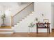 Staircase features hardwood steps, white risers, and elegant black metal spindles and newel post at 2571 S Cherokee St, Denver, CO 80223