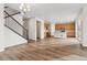Bright, open-concept living room with hardwood floors, staircase, and kitchen in a modern home at 39731 Congress Ln, Elizabeth, CO 80107