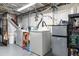 Laundry area in the basement featuring modern appliances and ample storage for cleaning supplies at 4110 Yates St, Denver, CO 80212