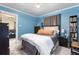 Comfortable bedroom with natural light, warm-toned hardwood floor and complemented by soft blue painted walls at 4110 Yates St, Denver, CO 80212