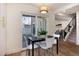 Cozy dining room with a modern light fixture and view into the living room, staircase, and kitchen at 9695 E Kansas Cir # 44, Denver, CO 80247