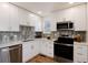Modern kitchen featuring white cabinetry, stainless steel appliances, and stylish backsplash at 9695 E Kansas Cir # 44, Denver, CO 80247