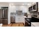 Modern kitchen featuring stainless steel appliances, white cabinets, and stylish backsplash at 9695 E Kansas Cir # 44, Denver, CO 80247