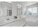 Bathroom features double sinks, quartz countertops, natural light, and a tub with glass enclosed shower at 11680 Crow Hill Dr, Parker, CO 80134