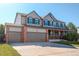 Beautiful home featuring a covered front porch, three-car garage, and well-maintained lawn at 11680 Crow Hill Dr, Parker, CO 80134