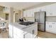 Well-lit kitchen island with cooktop and stainless refrigerator with ample counter space at 11680 Crow Hill Dr, Parker, CO 80134