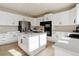 Charming kitchen boasts white cabinets, an island with cooktop, and modern appliances at 11680 Crow Hill Dr, Parker, CO 80134