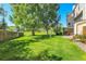 Large grassy backyard surrounded by a wooden fence and shade trees at 9320 W Ontario Dr, Littleton, CO 80128