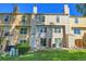 Exterior backyard view of townhouse units with a well-maintained lawn at 9320 W Ontario Dr, Littleton, CO 80128