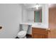 Bathroom features a single sink vanity, toilet, and large mirror at 9320 W Ontario Dr, Littleton, CO 80128