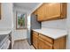 Bright kitchen with white countertops, stainless steel refrigerator, and wood cabinets at 9320 W Ontario Dr, Littleton, CO 80128