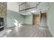 Spacious living room with fireplace, stairs, and loft area, featuring gray wood flooring at 9320 W Ontario Dr, Littleton, CO 80128