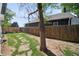 Backyard featuring a mature tree, a wooden fence, and a partially shaded lawn with a stone path at 3817 Osage St, Denver, CO 80211