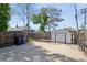 Backyard featuring a shed, concrete patio area, bordered by a wooden fence, and mature trees providing shade at 3817 Osage St, Denver, CO 80211