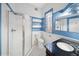 Well-lit bathroom with blue accent wall, white tile, a glass-enclosed shower, and a dark vanity at 3817 Osage St, Denver, CO 80211