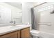 Bright bathroom featuring a shower-tub combo with white tile and a light wood vanity at 5570 Perth Ct, Denver, CO 80249