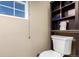 Cozy half-bathroom featuring a toilet and built-in shelving for storage at 5570 Perth Ct, Denver, CO 80249
