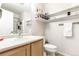 Bathroom features a vanity with an oval sink, a toilet, shelves and a glass enclosed shower at 5570 Perth Ct, Denver, CO 80249