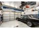 Spacious garage with a black car parked inside and overhead storage racks at 5570 Perth Ct, Denver, CO 80249