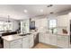 Modern kitchen with stainless steel appliances, white cabinets, and a view of the dining area and sliding glass doors at 5570 Perth Ct, Denver, CO 80249