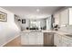 Bright kitchen with stainless steel appliances, white cabinets, and an open view to the dining area and staircase at 5570 Perth Ct, Denver, CO 80249