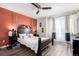 A primary bedroom featuring a four-poster bed, ceiling fan, and windows with sheer curtains at 5570 Perth Ct, Denver, CO 80249