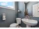 Powder room with a pedestal sink, wall mirror, and blue wall color at 5471 W 97Th Pl # E, Broomfield, CO 80020