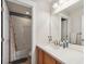 Bright bathroom featuring a shower over tub with a white tile surround and neutral vanity at 5471 W 97Th Pl # E, Broomfield, CO 80020