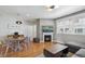 Open-concept living room with hardwood floors, a fireplace, a modern lighting fixture, and comfortable seating at 5471 W 97Th Pl # E, Broomfield, CO 80020