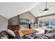 Open living room with vaulted ceilings, hardwood floors, TV, and bar area with rooftop access at 5471 W 97Th Pl # E, Broomfield, CO 80020