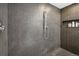 Close-up of a modern shower with dark, textured tile and a built-in niche at 5471 W 97Th Pl # E, Broomfield, CO 80020