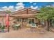 Charming brick back patio with covered area, outdoor seating, and lush tree providing shade and privacy at 55 S Flower St, Lakewood, CO 80226