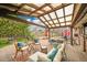Inviting back patio with an open roof structure, patio furniture, a dining table, and well maintained brick pavers at 55 S Flower St, Lakewood, CO 80226