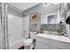 Charming bathroom features a tub and shower, a gray wall, and mosaic tile at 55 S Flower St, Lakewood, CO 80226