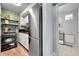 Galley kitchen featuring stainless refrigerator, and view to bathroom with tile flooring at 55 S Flower St, Lakewood, CO 80226