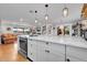 Bright, open kitchen features a large island, white cabinetry and stainless steel appliances at 55 S Flower St, Lakewood, CO 80226