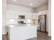 Bright kitchen featuring stainless steel appliances, a kitchen island and white cabinets at 485 Interlocken Blvd # 101, Broomfield, CO 80021