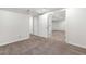 Finished basement showcasing neutral carpet and white trim, leading to additional rooms at 5471 S Sherman St, Littleton, CO 80121