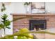 Close up of a stone fireplace with a black insert and decorated with an artful plant and an ornate painting at 5471 S Sherman St, Littleton, CO 80121